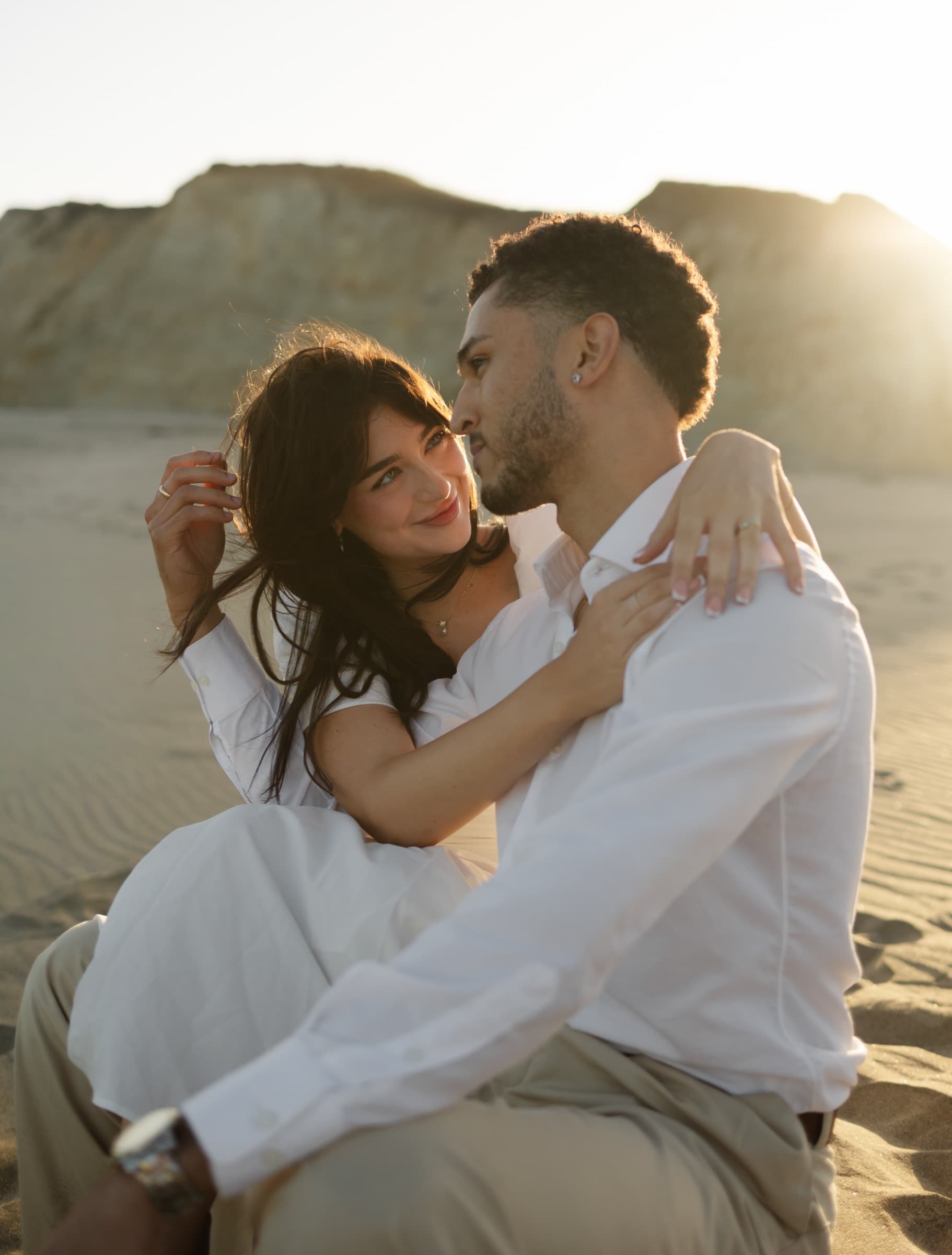 Berkeley and Robin embracing at sunset on the sand at Drake's Beach